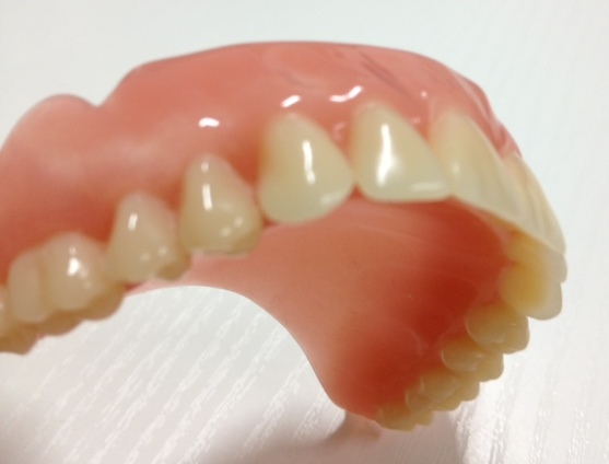 Complete upper denture shown from the side with visible denture teeth and base